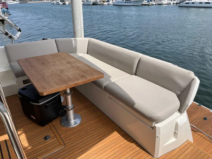 Simorgh Yacht Photos Pics Outdoor seating area on a 2019 Prestige 460 yacht with a wooden table.