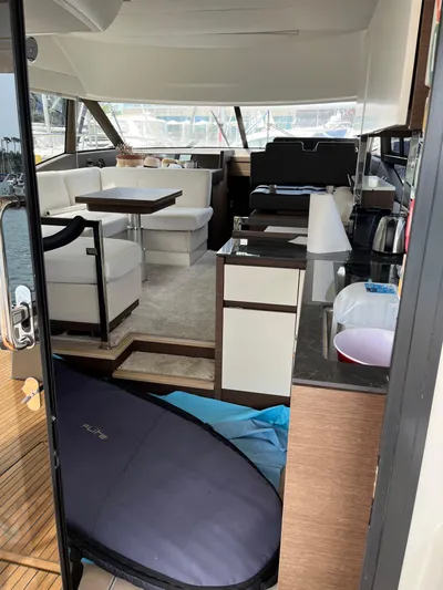 Simorgh Yacht Photos Pics Interior of 2019 Prestige 460 yacht with modern furnishings and surfboard.