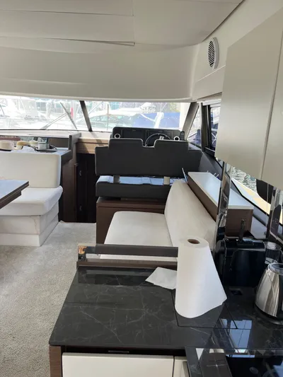 Simorgh Yacht Photos Pics Interior of a 2019 Prestige 460 yacht with modern furnishings and kitchen area.