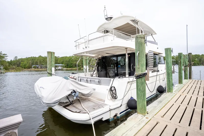 Sweetest Southern Comfort Yacht Photos Pics 2022 Beneteau ST48 Swift Trawler docked, rear view with covered dinghy.
