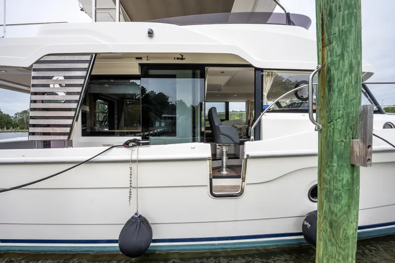 Sweetest Southern Comfort Yacht Photos Pics 2022 Beneteau ST48 Swift Trawler docked, side view with open cabin and visible seating.