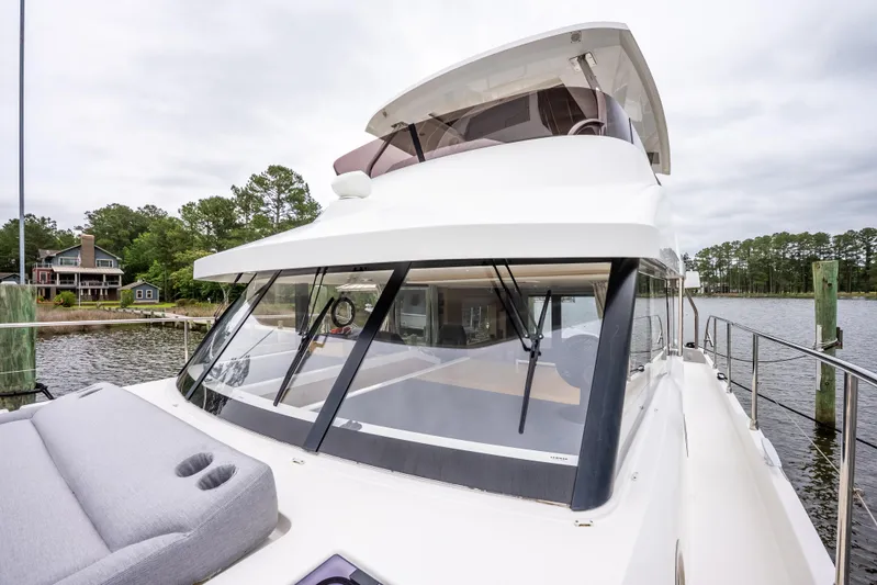 Sweetest Southern Comfort Yacht Photos Pics 2022 Beneteau ST48 Swift Trawler 48 docked by a scenic waterfront.