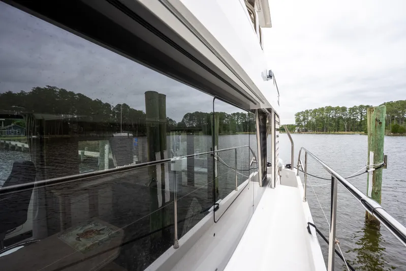 Sweetest Southern Comfort Yacht Photos Pics 2022 Beneteau ST48 Swift Trawler 48 docked by a serene waterfront.