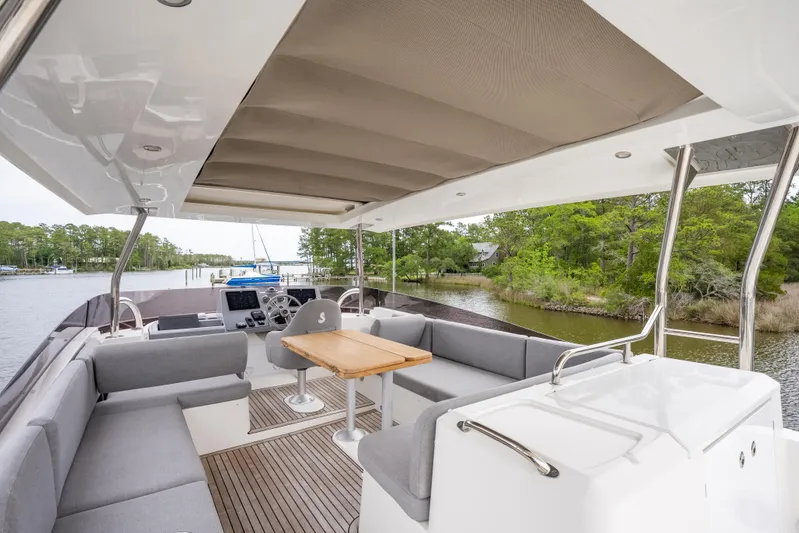 Sweetest Southern Comfort Yacht Photos Pics 2022 Beneteau ST48 Swift Trawler 48, spacious deck with seating and table, docked by a river.