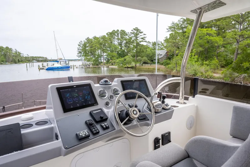 Sweetest Southern Comfort Yacht Photos Pics Helm of 2022 Beneteau ST48 Swift Trawler 48 with modern controls, overlooking serene waters.