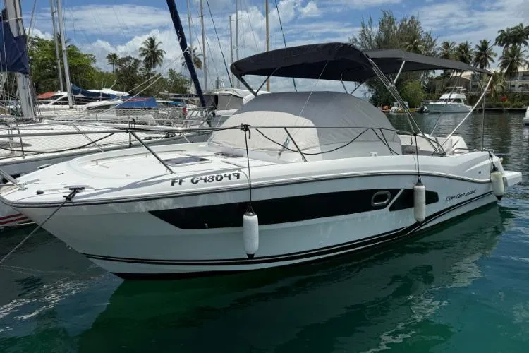 P'tit Bateau Yacht Photos Pics 2022 Jeanneau Cap Camarat 9.0 WA boat docked in a marina, under a clear sky.
