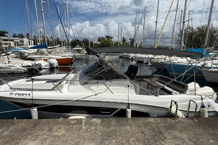 P'tit Bateau Yacht Photos Pics 2022 Jeanneau Cap Camarat 9.0 WA boat docked in a marina under a cloudy sky.