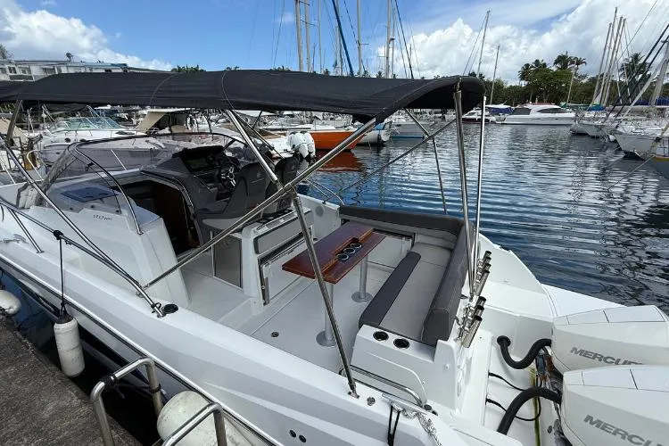 P'tit Bateau Yacht Photos Pics 2022 Jeanneau Cap Camarat 9.0 WA boat docked in marina, featuring spacious seating and canopy.