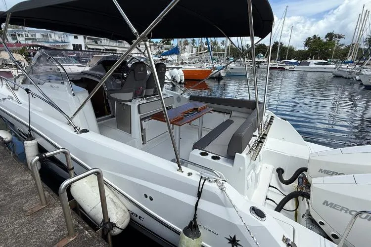 P'tit Bateau Yacht Photos Pics 2022 Jeanneau Cap Camarat 9.0 WA boat docked at marina, featuring spacious seating and canopy.