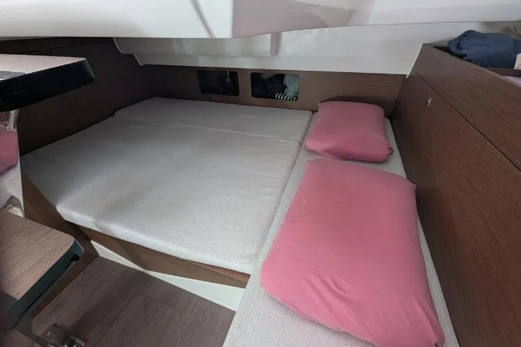 P'tit Bateau Yacht Photos Pics Interior cabin of 2022 Jeanneau Cap Camarat 9.0 WA with pink pillows and wooden accents.