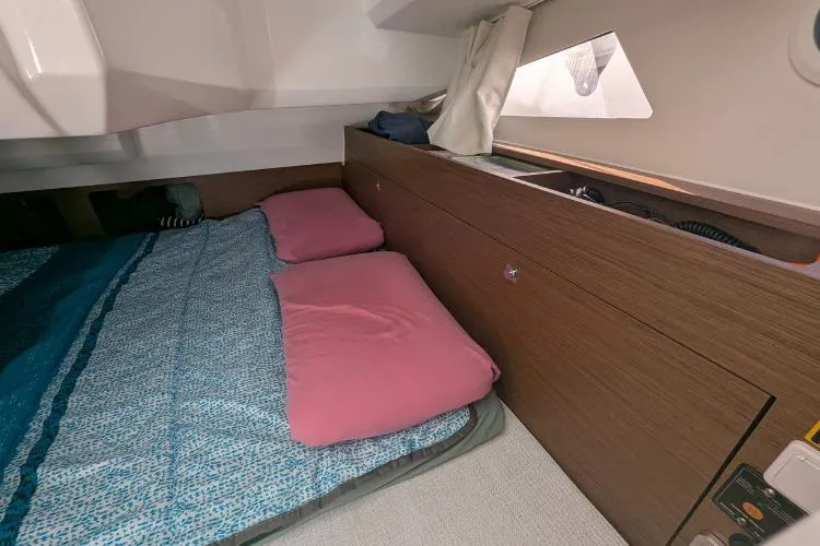 P'tit Bateau Yacht Photos Pics Cozy cabin interior of 2022 Jeanneau Cap Camarat 9.0 wa with pink pillows and wood paneling.