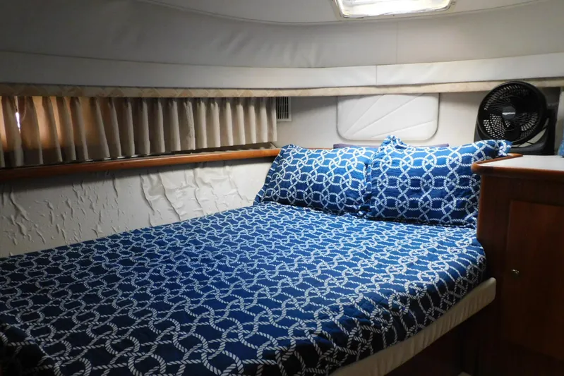La Vida Yacht Photos Pics Cozy bedroom in 1993 Carver 445 Aft Cabin Motor Yacht with nautical-themed bedding.