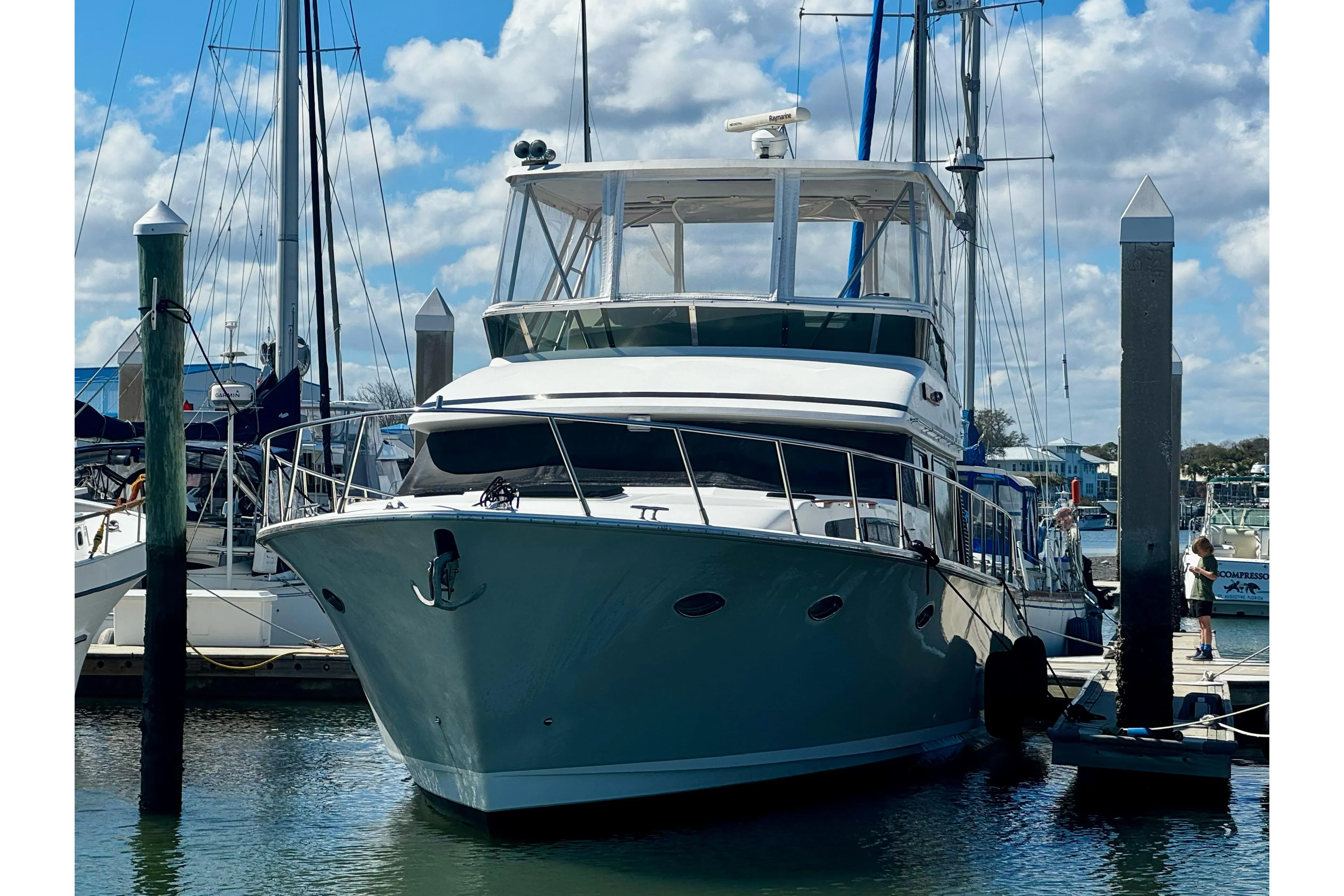 1998 Mikelson 43 Sportfisher yacht docked at marina under blue sky.