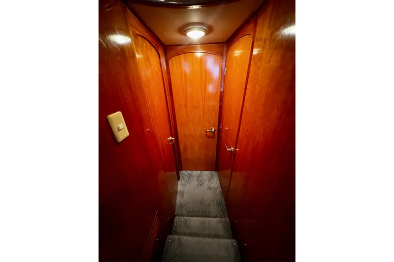 Gullwing Yacht Photos Pics Wood-paneled hallway inside 1998 Mikelson 43 Sportfisher yacht, featuring elegant doors and soft lighting.