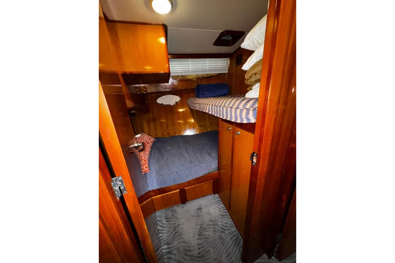 Gullwing Yacht Photos Pics Cozy cabin interior of 1998 Mikelson 43 Sportfisher with wooden finish and bunk beds.