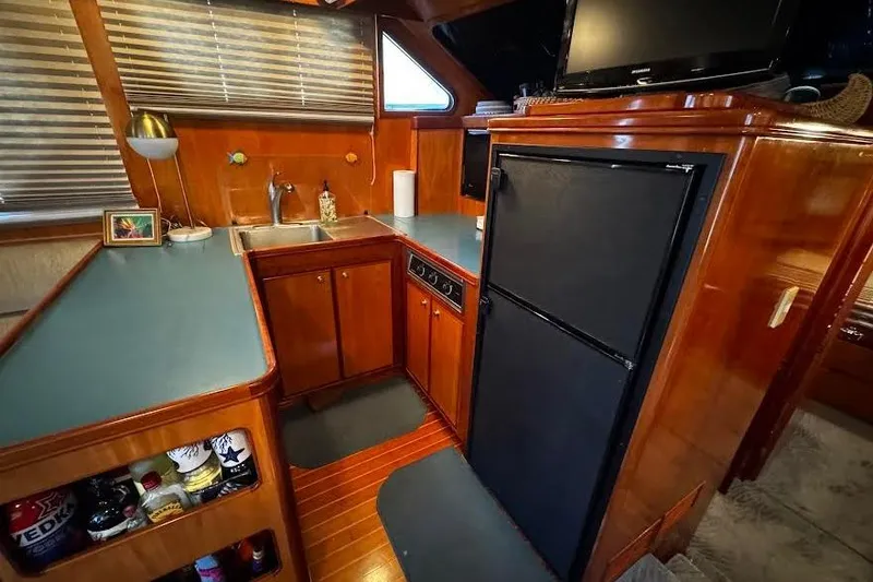 Gullwing Yacht Photos Pics 1998 Mikelson 43 Sportfisher yacht kitchen with wood cabinetry and modern appliances.