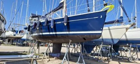  Yacht Photos Pics Beneteau Oceanis Clipper 393 sailboat, 2006 model, on dry dock with blue hull and fenders.