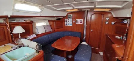  Yacht Photos Pics Interior of 2006 Beneteau Oceanis Clipper 393 yacht with wooden furnishings and blue seating.