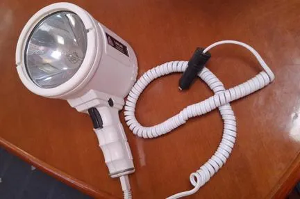  Yacht Photos Pics Handheld spotlight with coiled cord on a wooden surface, related to Beneteau Oceanis Clipper 393.