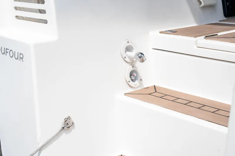  Yacht Photos Pics Dufour 530 yacht, 2023 model, featuring sleek white exterior and wooden steps.