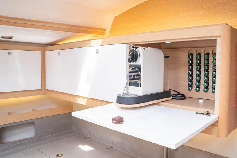  Yacht Photos Pics Modern kitchen area in 2023 Dufour 530 yacht with coffee machine and capsule storage.