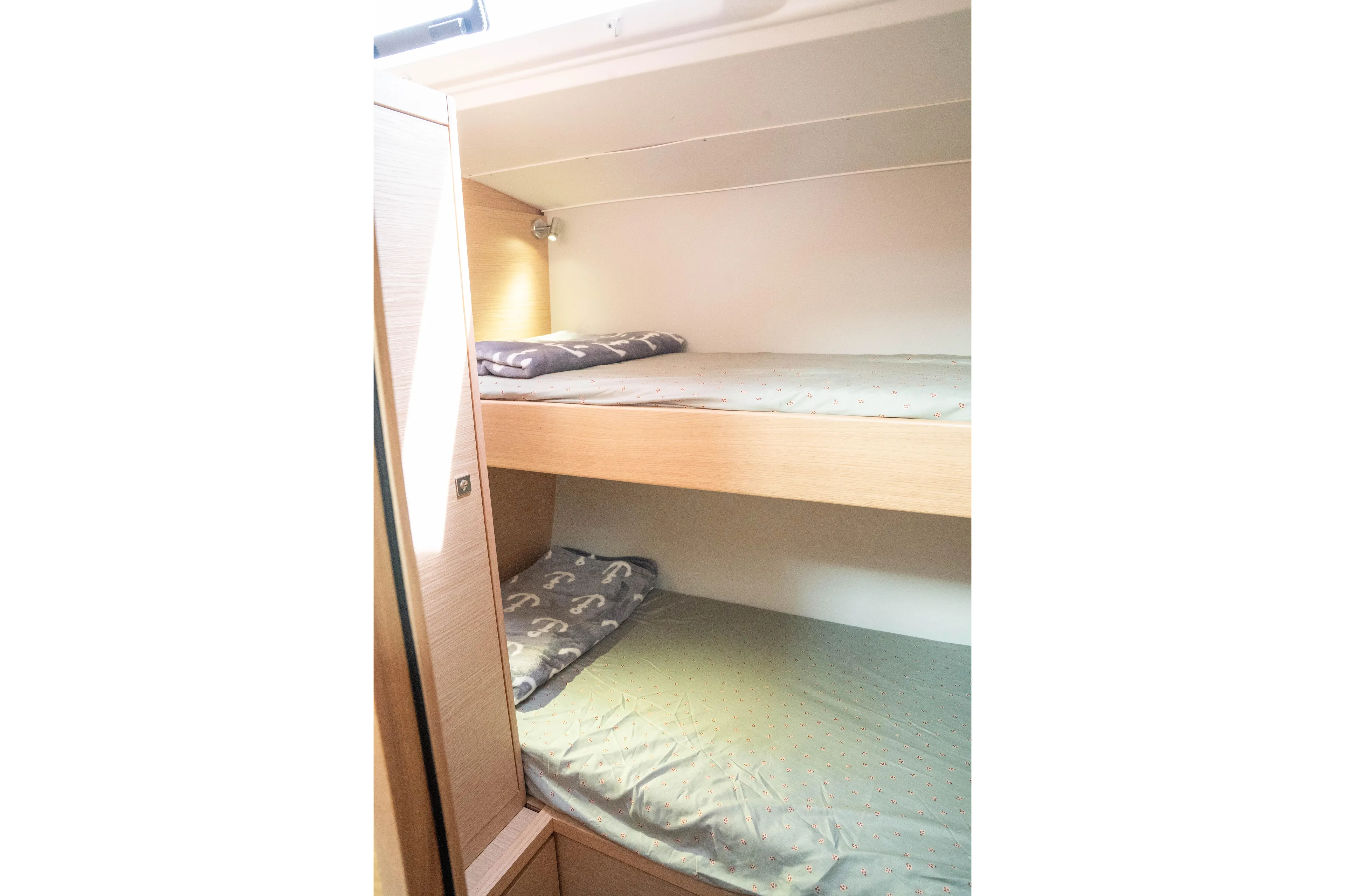  Yacht Photos Pics 2023 Dufour 530 yacht interior with cozy bunk beds and soft lighting.