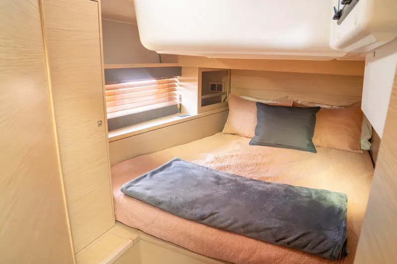  Yacht Photos Pics Cozy cabin interior of 2023 Dufour 530 yacht with comfortable bedding and wooden accents.