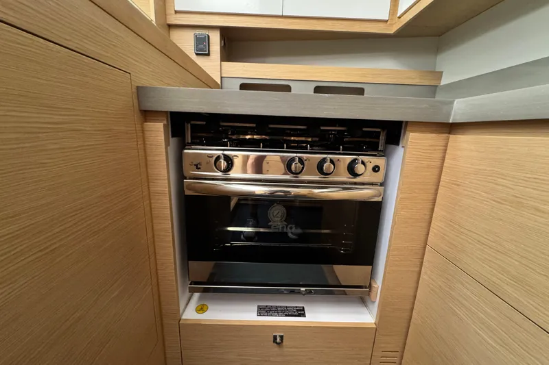  Yacht Photos Pics Modern kitchen oven in 2023 Dufour 530 yacht, featuring sleek wooden cabinetry.
