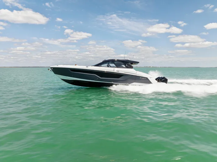  Yacht Photos Pics 2023 Cruisers Yachts 50 GLS speeding on open water under a clear sky.