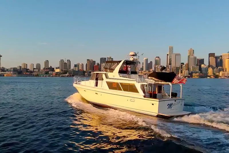 Mbellish Yacht Photos Pics 1988 Symbol 51 Motoryacht cruising near city skyline at sunset.