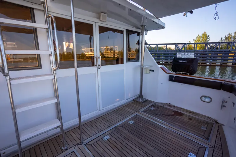 Mbellish Yacht Photos Pics 1988 Symbol 51 Motoryacht deck with ladder, wooden flooring, and water view.
