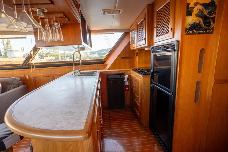 Mbellish Yacht Photos Pics Luxurious 1988 Symbol 51 Motoryacht kitchen with wood cabinetry and modern appliances.