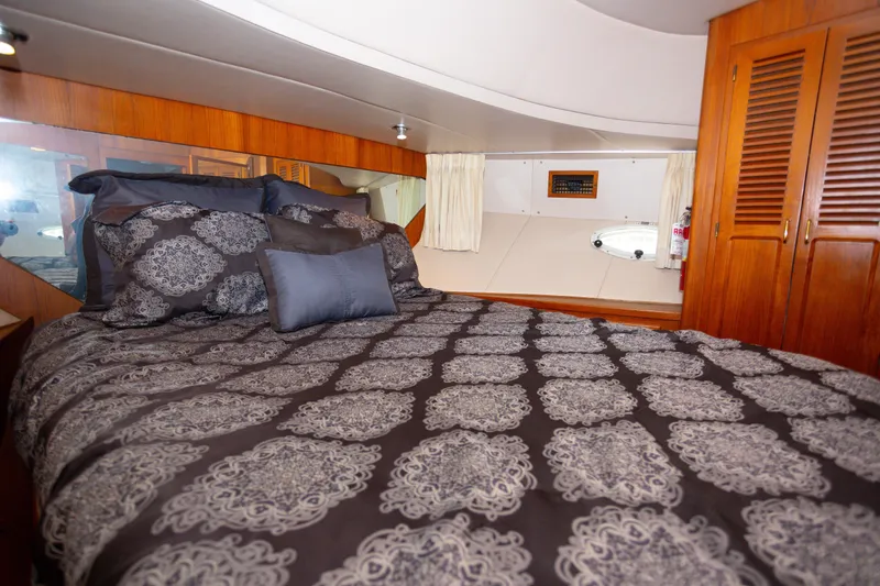 Mbellish Yacht Photos Pics Luxurious bedroom interior of 1988 Symbol 51 Motoryacht with elegant bedding and wooden cabinetry.