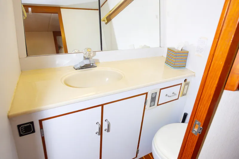 Mbellish Yacht Photos Pics 1988 Symbol 51 Motoryacht bathroom with sink, mirror, and storage cabinet.