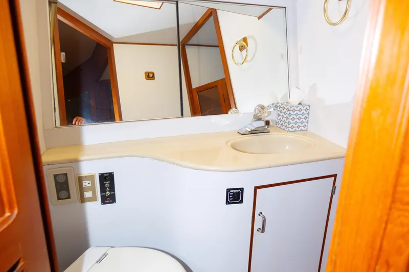 Mbellish Yacht Photos Pics Bathroom interior of 1988 Symbol 51 Motoryacht with sink, mirror, and wooden accents.