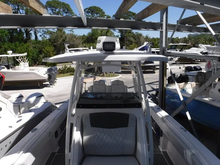  Yacht Photos Pics 2018 Fountain 34CC boat in marina, surrounded by other vessels and greenery.