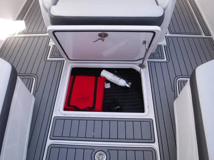  Yacht Photos Pics 2018 Fountain 34CC boat storage compartment with red bag and white bottle.