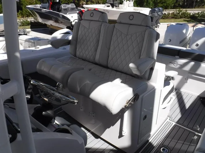  Yacht Photos Pics 2018 Fountain 34CC boat with luxurious white seating and modern steering wheel.