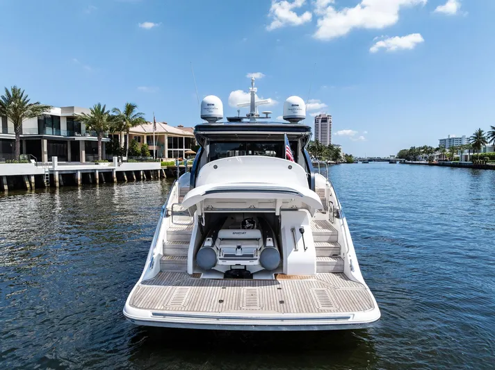 Endless Summer Yacht Photos Pics 2020 Princess V55 yacht docked on a sunny waterfront with palm trees.