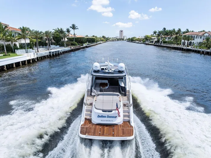 Endless Summer Yacht Photos Pics 2020 Princess V55 yacht cruising on a scenic waterway with palm trees and luxury homes.