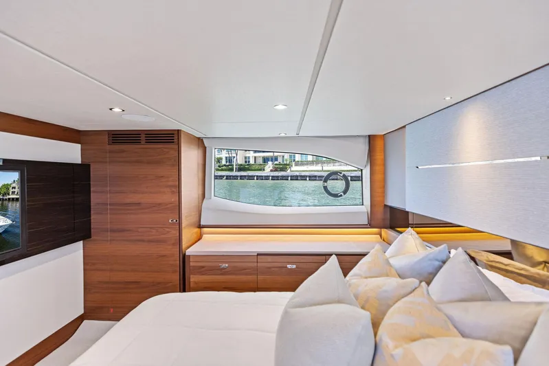 Endless Summer Yacht Photos Pics Luxurious interior of 2020 Princess V55 yacht with elegant wood finishes and plush bedding.