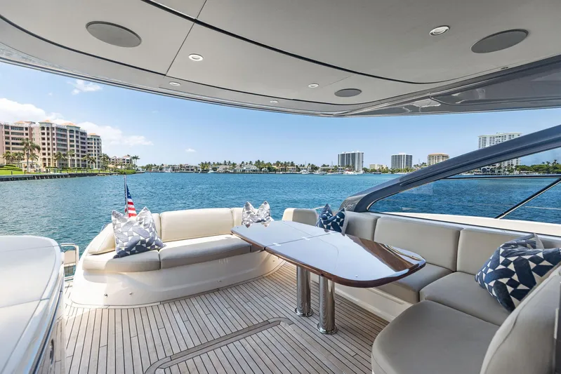 Endless Summer Yacht Photos Pics Luxurious 2020 Princess V55 yacht deck with elegant seating and scenic waterfront view.