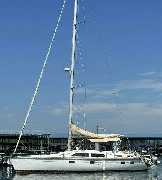 1991 Hunter Passage 42 sailboat docked at marina under clear blue sky.