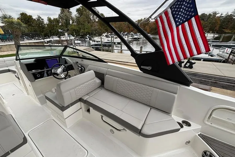  Yacht Photos Pics 2023 Sea Ray SDX 270 Outboard boat interior with American flag, docked at marina.