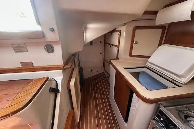 Otter Yacht Photos Pics Interior of 2000 Catalina 42 Mk II sailboat, featuring compact kitchen and wooden flooring.