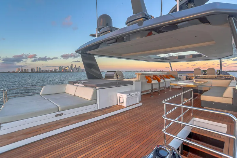 Our Trade Yacht Photos Pics Luxurious 2021 Sirena 88 yacht deck with city skyline at sunset.