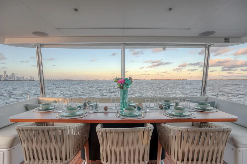 Our Trade Yacht Photos Pics Elegant dining setup on Sirena 88 yacht, 2021, with ocean view at sunset.