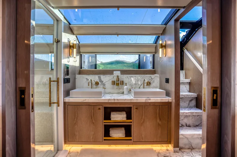 Our Trade Yacht Photos Pics Luxurious bathroom on 2021 Sirena 88 yacht with marble finishes and modern fixtures.