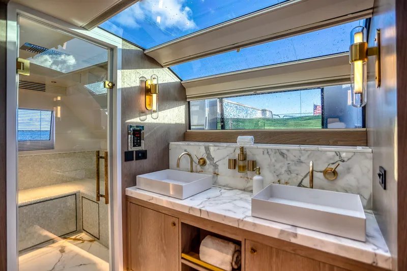 Our Trade Yacht Photos Pics Luxurious bathroom interior of 2021 Sirena 88 yacht with marble countertops and skylight.