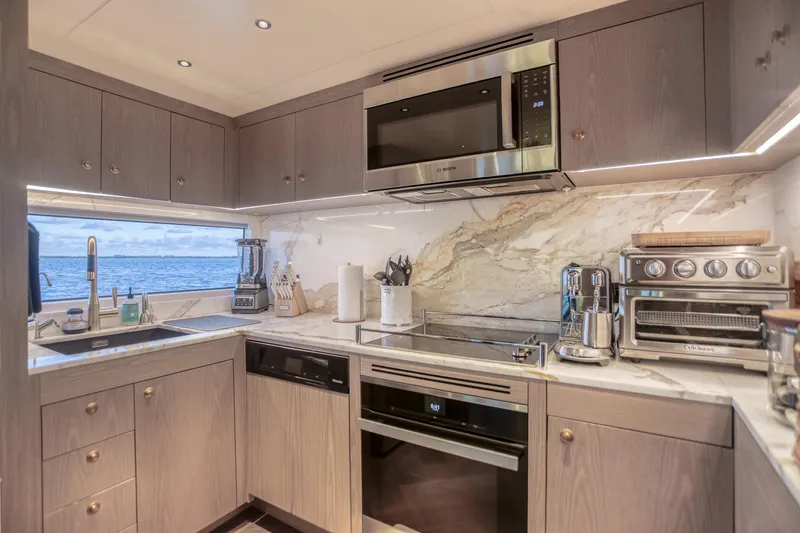 Our Trade Yacht Photos Pics Modern kitchen interior on 2021 Sirena 88 yacht with ocean view and sleek appliances.
